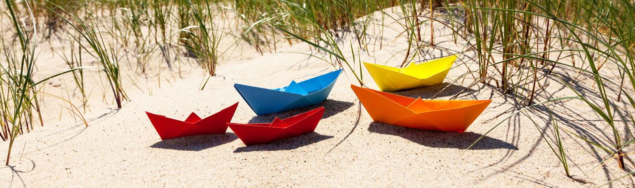 Bunte Papierschiffe am Strand